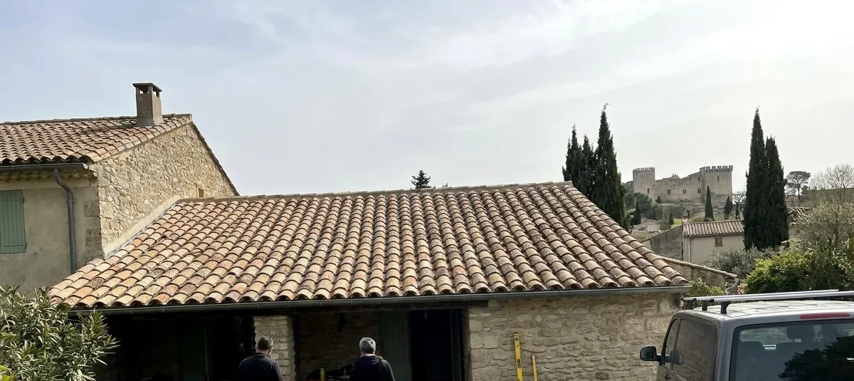 Toiture en tuiles canal refaite par Face aux Papes Toitures sur une maison en pierre de Villeneuve-lès-Avignon, fort Saint-André au loin